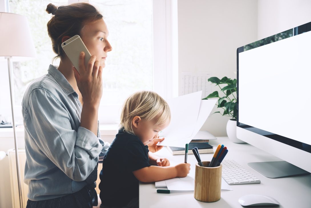 Mama telefonuje i trzyma małe dziecko na kolanach