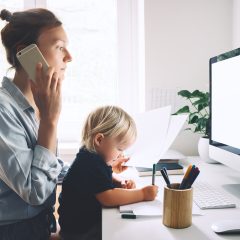 Mama telefonuje i trzyma małe dziecko na kolanach