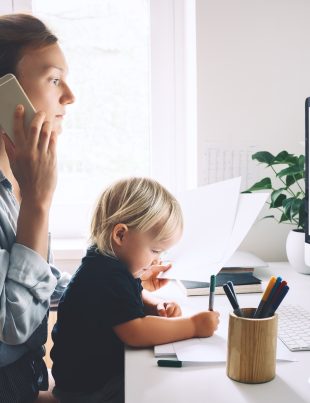 Mama telefonuje i trzyma małe dziecko na kolanach
