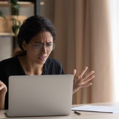 Zdenerwowana kopieta patrzy na ekran laptopa