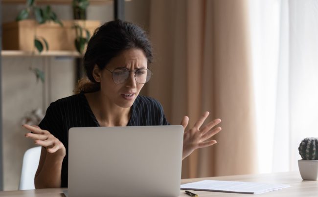 Zdenerwowana kopieta patrzy na ekran laptopa