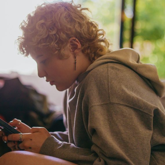 Młoda dziewczyna patrzy w ekran smartfona