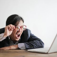 Mężczyzna z niedowierzaniem patrzy na ekran laptopa